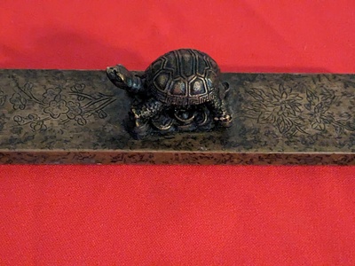 Curiosa - Een bronzen rechthoekige presse-papier met een schildpad erop