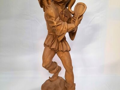 A wooden sculpture of a court jester with an owl